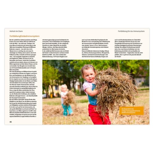 Zwei Kinder spielen mit Heu auf einem Feld auf einer Zeitschriftenseite mit deutschem Text.
