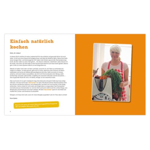 Aufgeschlagenes Kochbuch mit einem Rezepttext und einem Foto einer Person, die in einer Küche Gemüse hält.