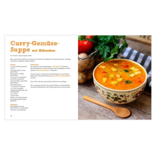 Eine Kochbuchseite mit einer Schüssel Curry-Gemüsesuppe mit Hühnchen auf einem Holztisch.