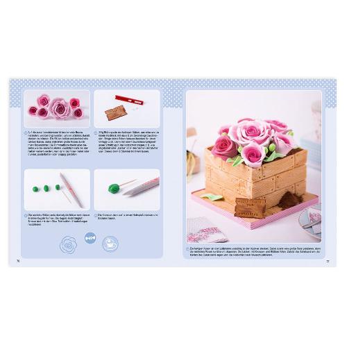 Öffnen Sie das Kochbuch und sehen Sie eine Seite mit Anleitungen und das Bild eines mit rosa Rosen dekorierten Kuchens.