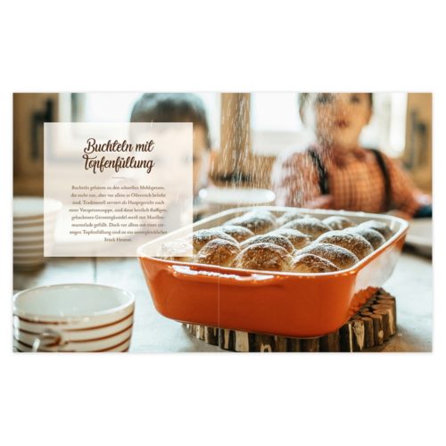Ein Blech mit gebackenen Brötchen wird mit Puderzucker bestäubt, im Hintergrund sind Kinder und eine gemütliche Küche zu sehen.