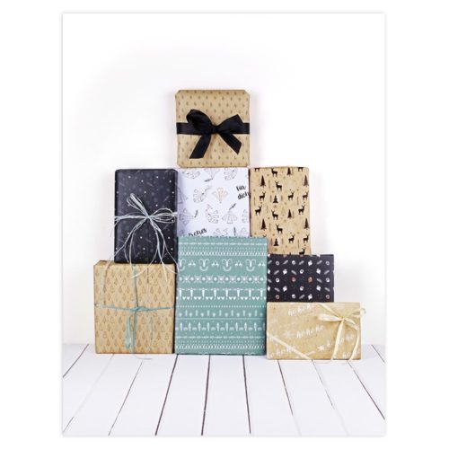 Ein Stapel aus sieben in verschieden gemustertes Papier und mit Schleifen verpackten Geschenken auf einem weißen Holzboden.