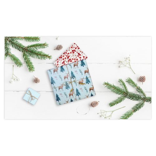 In festliches Papier verpackte Geschenke mit Tannenzweigen und Beeren auf einer weißen Holzoberfläche.