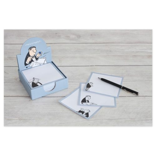 Schachtel mit Notizkarten mit Cartoon-Illustrationen und einem schwarzen Stift auf einer Holzoberfläche.