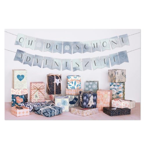 Verschiedene dekorierte Geschenkboxen und ein Adventsbanner auf weißem Hintergrund.