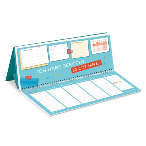 Tischkalender mit Text „Ich habe gekocht. Es gibt Kaffee“ und verschiedenen bunten Abschnitten für Notizen.