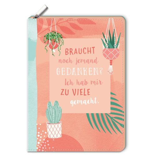 Notizbuch mit Pflanzenillustrationen und deutschem Text in der Mitte auf pfirsich- und blaugrünem Hintergrund.