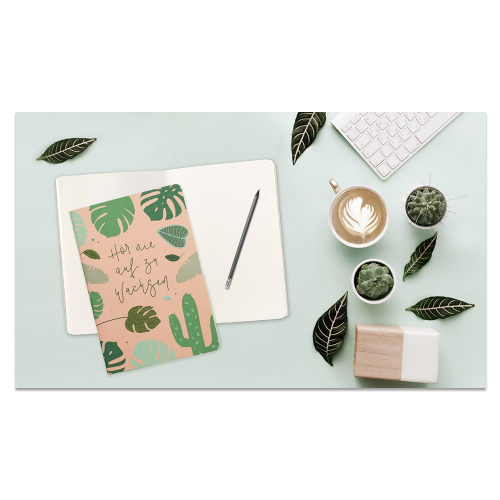 Schreibtisch mit Notizbuch, Bleistift, Kaffee, Tastatur, Kaktus und Blättern auf einer hellen Oberfläche.