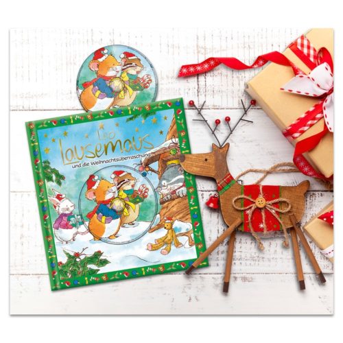 Buntes Kinderbuch mit Mäusen, Geschenken und Rentier-Dekoration auf einem weißen Holztisch.
