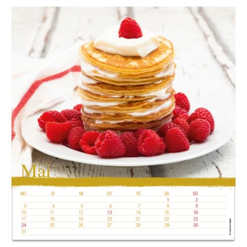 Ein Stapel Pfannkuchen mit Sahne und Himbeeren auf einem Teller, umgeben von weiteren Himbeeren. Mai-Kalender unten.