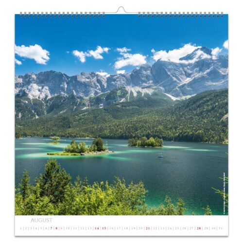 Kalenderseite mit einem malerischen See mit kleinen Inseln, umgeben von Bergen unter einem klaren blauen Himmel.