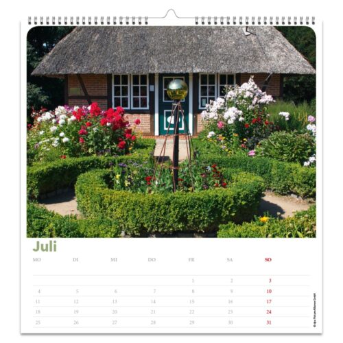 Ein rustikales Cottage mit Strohdach, umgeben von einem üppigen Garten in voller Blüte, abgebildet auf einer Kalenderseite für Juli.