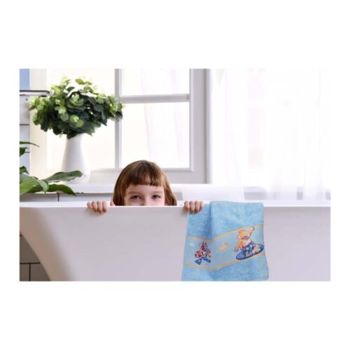 Kind späht über die Badewanne, an deren Rand ein blaues Handtuch mit verspielten Teddybärmotiven hängt.