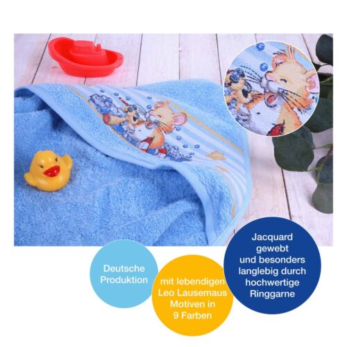 Blaues Handtuch mit einem Cartoon-Maus-Design, einer gelben Gummiente und einem roten Spielzeugboot auf einer Holzoberfläche.