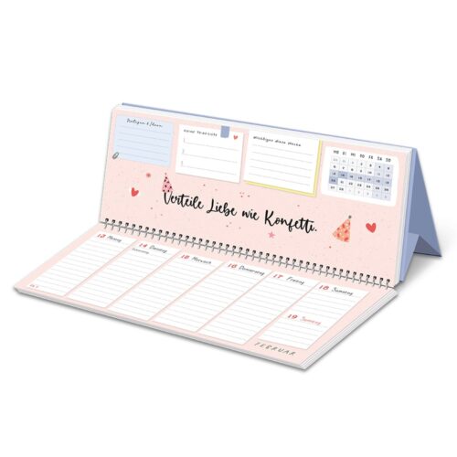 Ein spiralgebundener Kalender mit einer motivierenden Botschaft und Platz für Notizen, mit Herzen, Sternen und Haftnotizen.