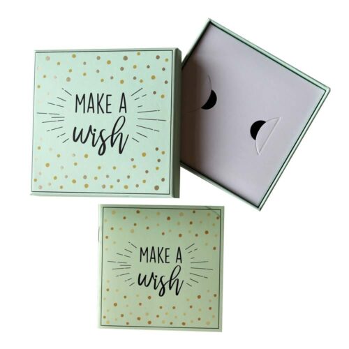 Zwei mintgrüne Schachteln, eine davon offen, mit dem Text „Make a Wish“ und goldenen Punkten auf den Deckeln.