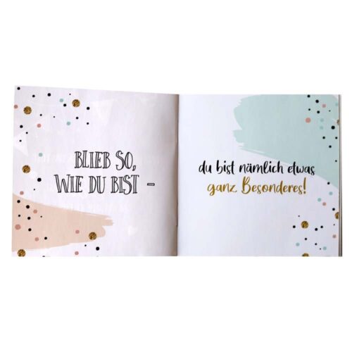 Offenes Buch mit dekorativem Text: „Bleib so, wie du bist – du bist nämlich etwas ganz Besonderes!“.