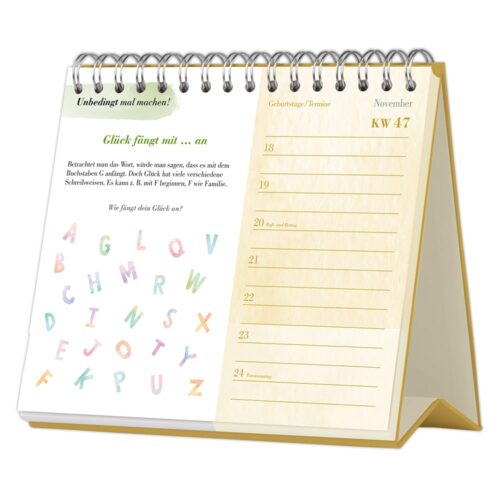 Ein spiralgebundener Tischkalender mit einem Zitat, bunten Buchstaben und einem Wochenplaner für November.